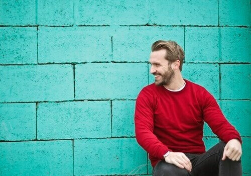 Uomo ride davanti a un muro blu