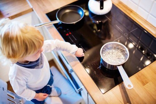 Bambino con pentole in cucina