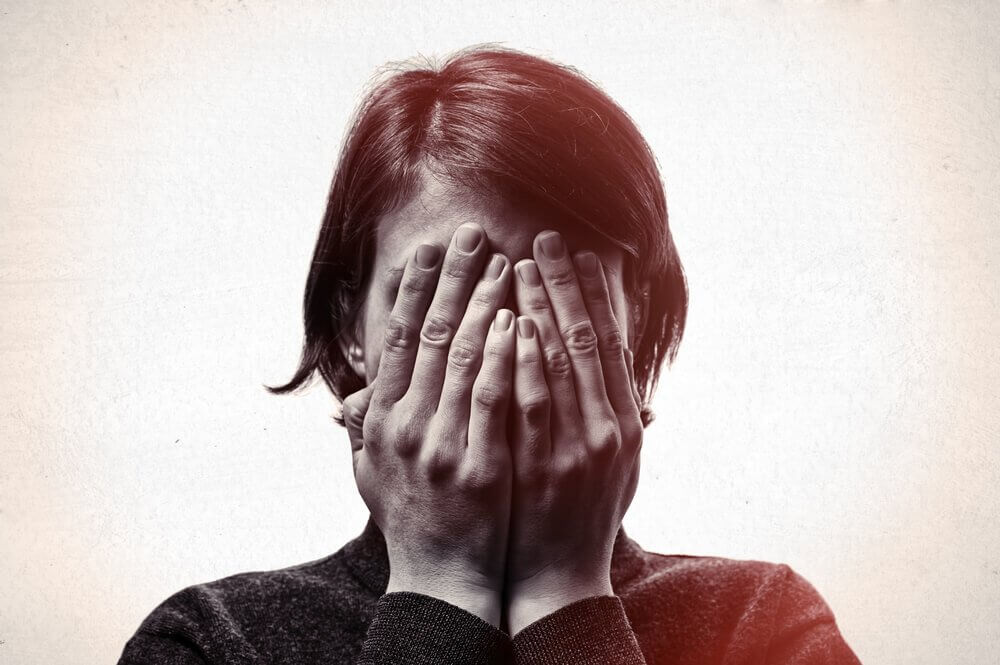 Essere troppo modesti rappresentato da donna che si copre il viso