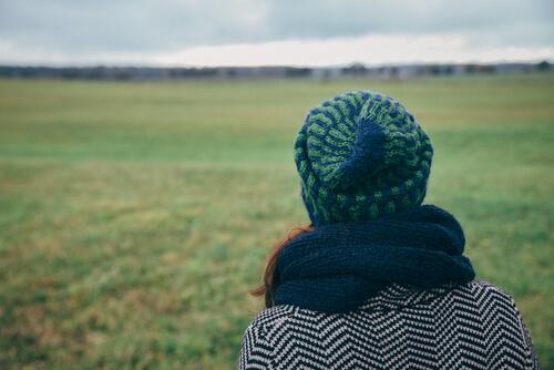 Ragazza di spalle con berretto e sciarpa