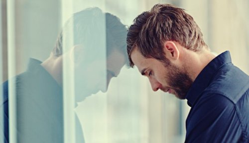 Uomo con testa appoggiata alla finestra