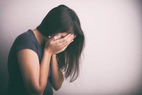 Donna si copre il volto piangendo