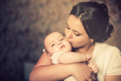 Le fasi del legame di attaccamento, madre che bacia il bambino