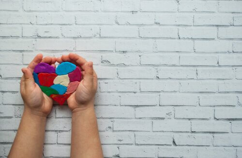 Mani di bambino con cuore colorato
