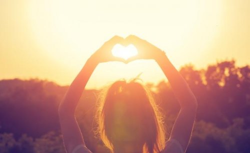 Ragazza con mani a cuore alba