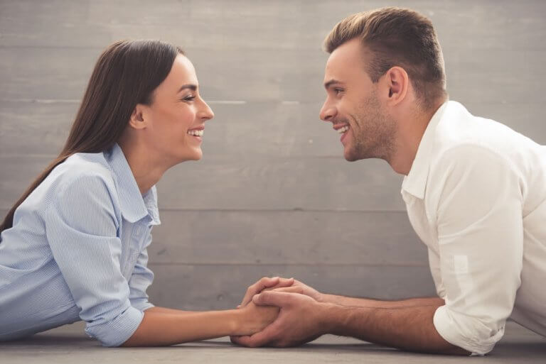 Uomo e donna sorridenti si guardano negli occhi
