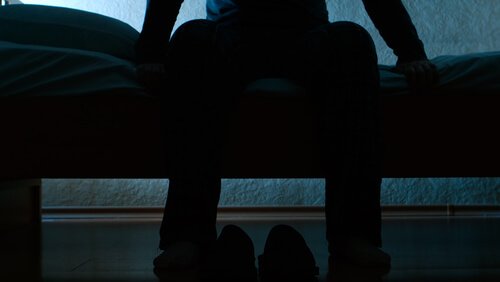 Uomo seduto sul letto