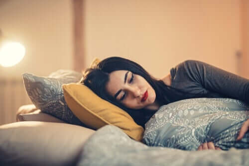 Donna triste sdraiata sul letto