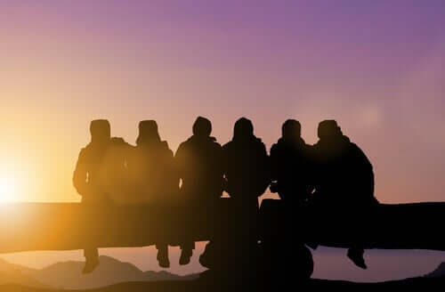 Amici seduti che guardano il tramonto