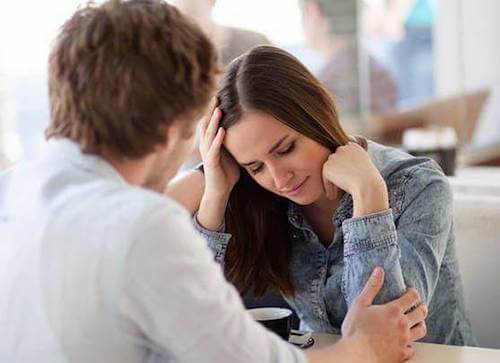 Coppia seduta al tavolo di un ristorante durante un litigio