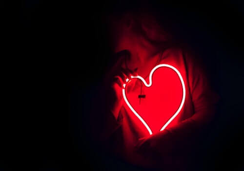 Donna con neon a forma di cuore