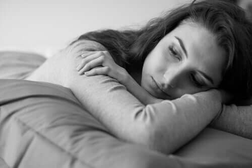 Donna pensierosa sul letto