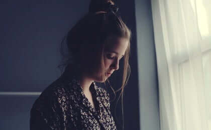 Giovane pensierosa con la testa abbassata