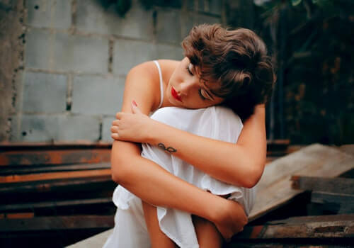 Ragazza triste con la testa sulle ginocchia