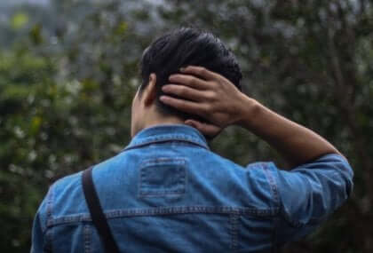 Ragazzo con la mano sulla nuca che ha la sindrome di Taijin kyofusho
