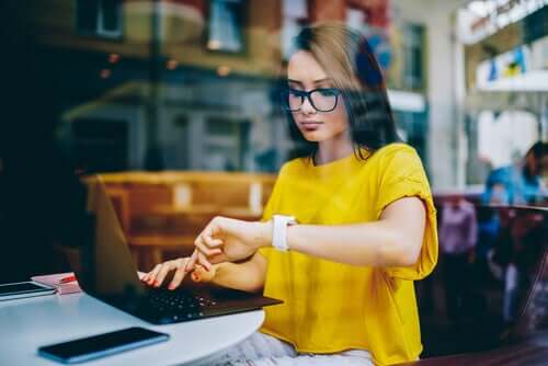 Ragazza al computer che guarda l'orologio