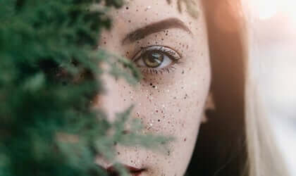 Donna dietro il ramo di un albero