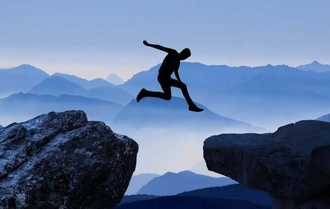Paura di fare il salto, uomo salta tra due rocce