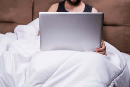 Uomo a letto col computer