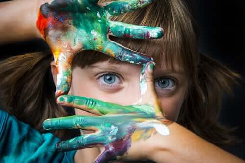 Bambina con le mani sporche di vernice