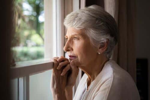 Donna che guarda dalla finestra con demenza corticale e sottocorticale
