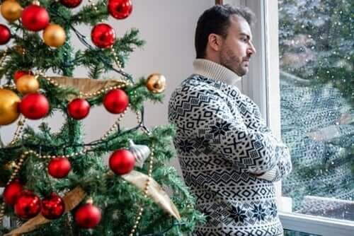 Uomo triste accanto all'albero di Natale