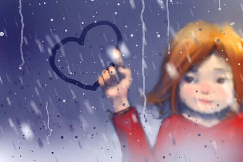 Bambina che disegna un cuore sulla finestra appannata