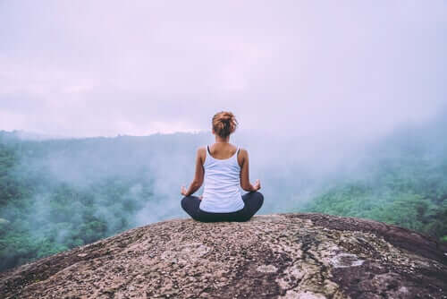 Zazen, donna medita sulla vetta di una montagna
