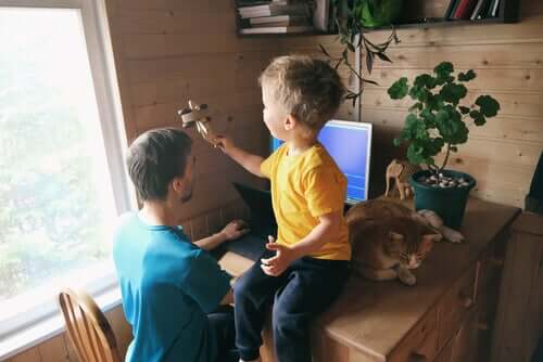 Bambino gioca e padre in telelavoro