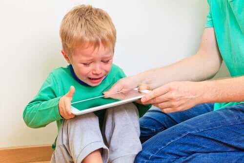 Mamma che dà il tablet al figlio che piange