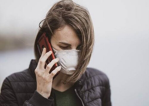 Donna con mascherina e cellulare