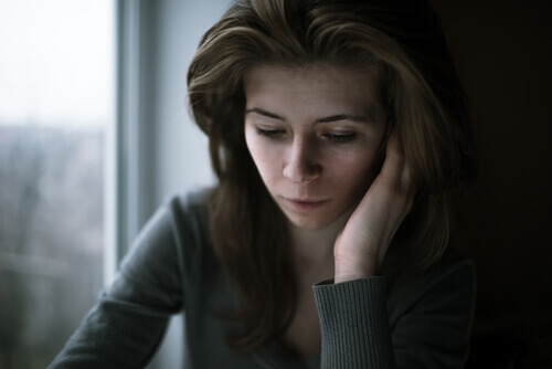 Ragazza pensierosa con la testa appoggiata sulla mano