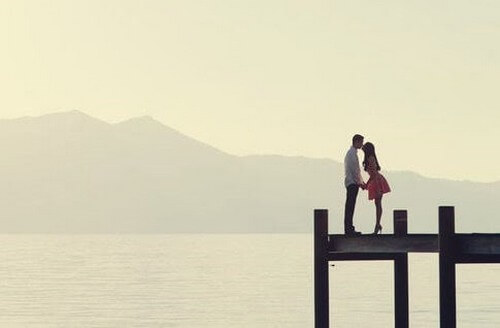 Frasi sull'amore e ragazzi che si baciano sul molo