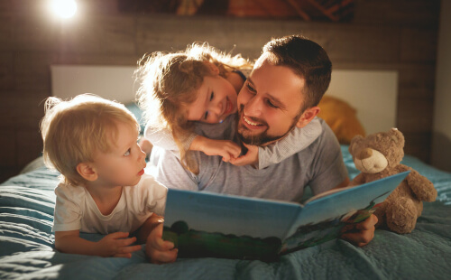 Padre legge libro ai suoi figli