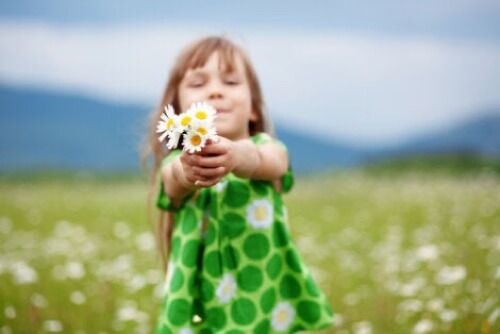 Bambina con fiori in mano.