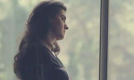 Donna alla finestra che riflette sul nuovo ecosistema del lavoro.