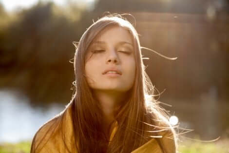 Donna con occhi chiusi che pratico lo slow living.