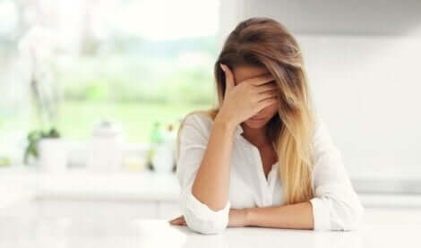 Donna triste con la mano sul viso.