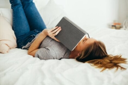 Ragazza a letto con un libro.