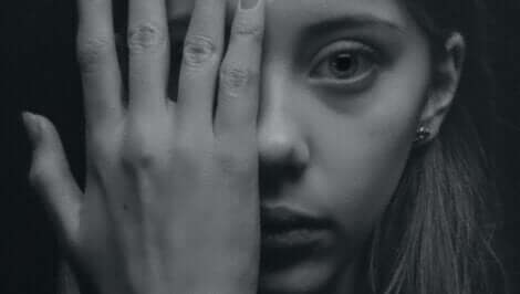 Ragazza che si copre un occhio con la mano.