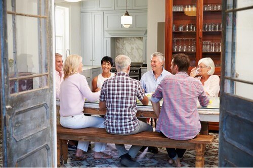 Gruppo di amici adulti seduti a un tavolo.
