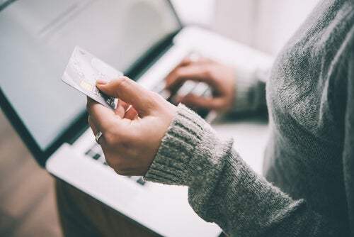 Donna che fa degli acquisti su Internet utilizzando la carta di credito.
