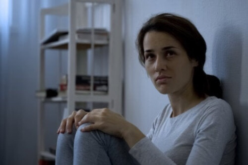 Ragazza triste seduta a terra.