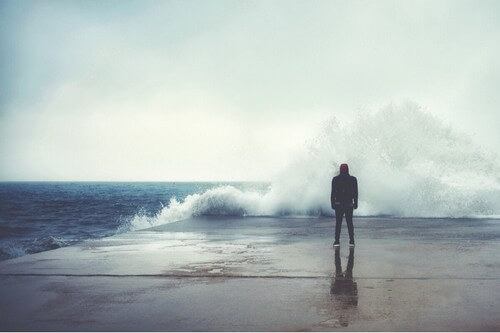Uomo davanti al mare in tempesta.