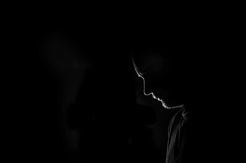 Profilo di un uomo nel buio.