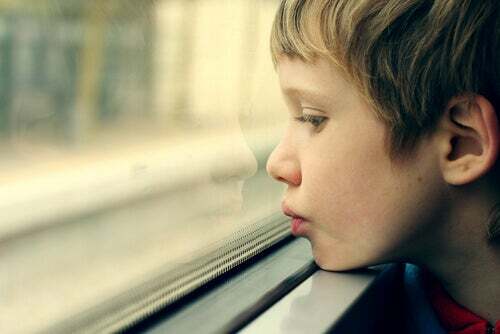 La neurobiologia del trauma e bambino autistico che guarda fuori dalla finestra.