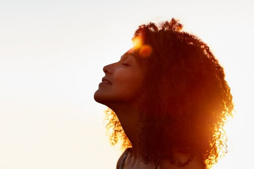 Donna rilassata con sole dietro.