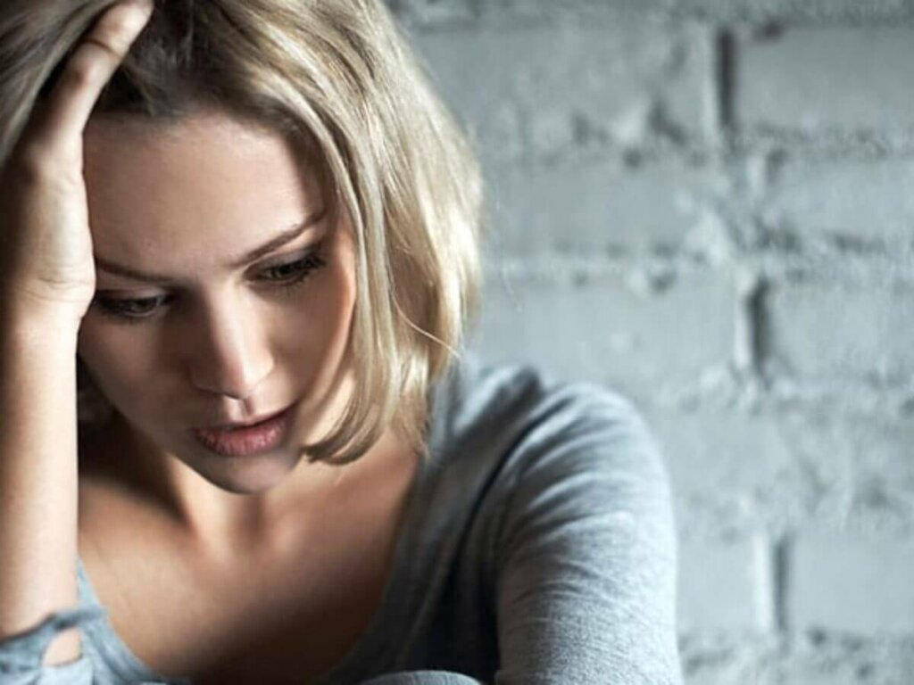 Donna triste con mano sui capelli.