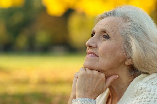 Donna anziana che guarda l'orizzonte.