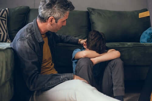 Padre che consola il figlio triste.